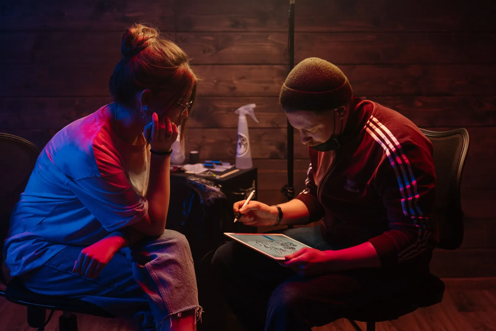 Consultație: artistul desenează pe tabletă, lângă client