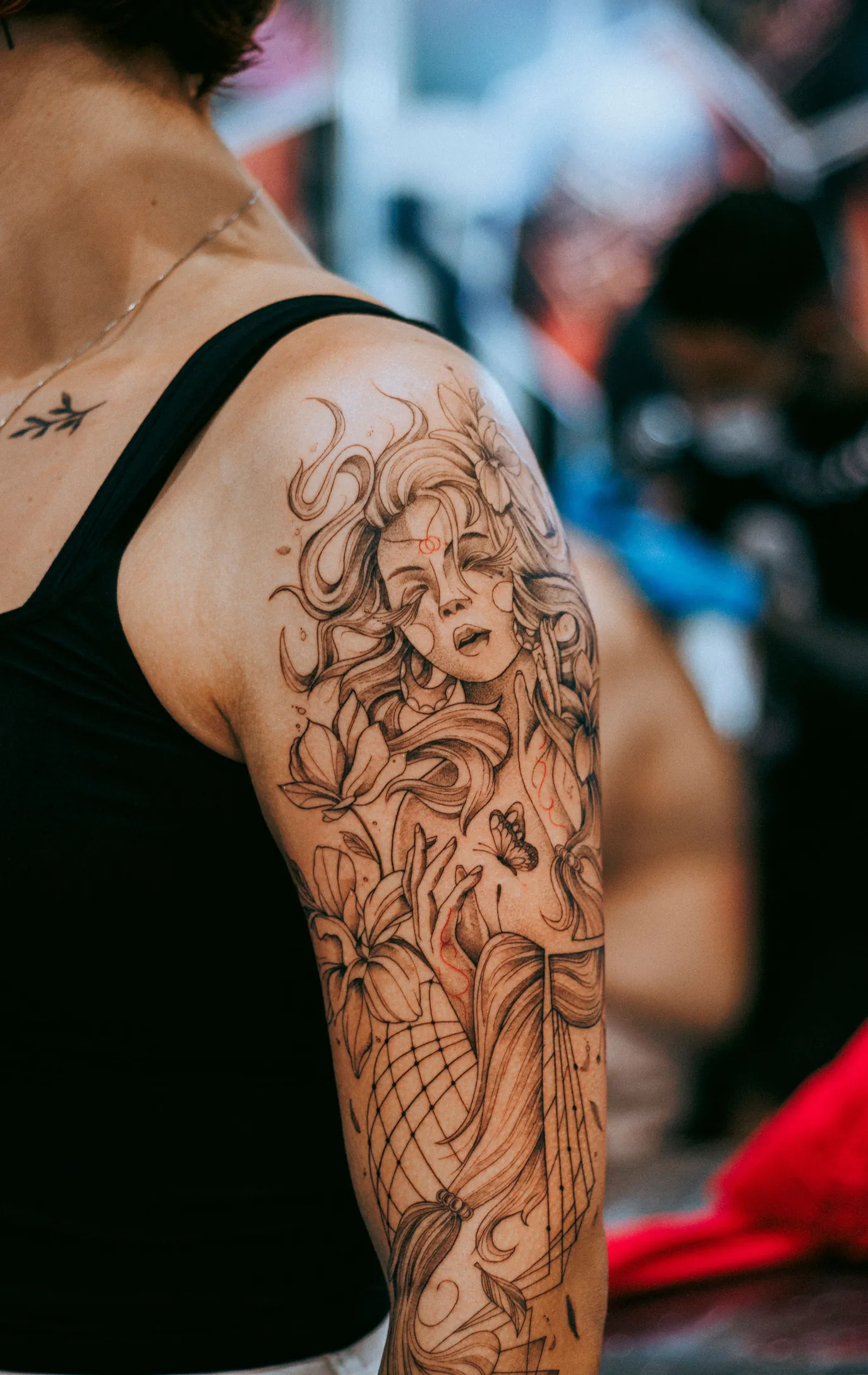 Portret de femeie cu păr ornamental, tatuat pe tot brațul