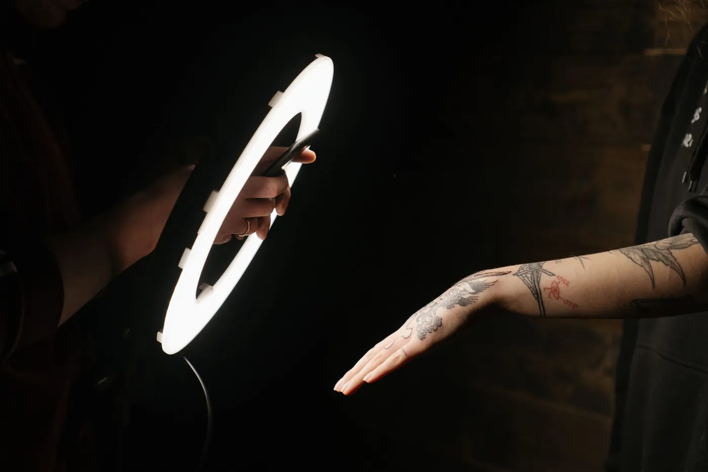 Mână tatuată în lumina inelului din studio