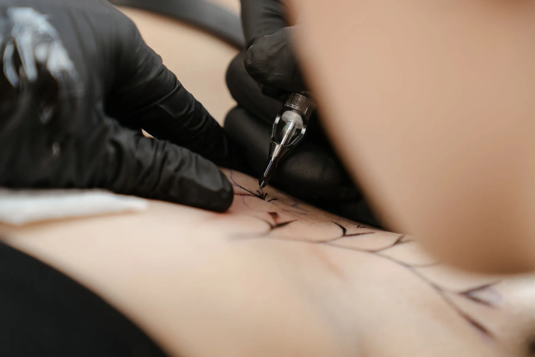 Aparatul de tatuat trage conturul fin peste stencil